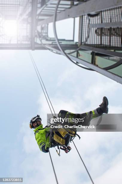 manual rope access technician - worker abseil from tower - antenna in sunshine - rappelling stock pictures, royalty-free photos & images