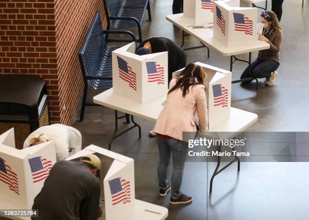 Voters mark their ballots in a polling place at Roosevelt High School on November 3, 2020 in Des Moines, Iowa. After a record-breaking early voting...