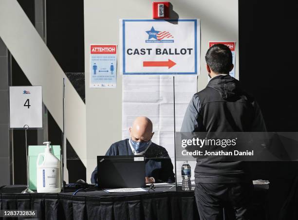 Poll worker checks the registration of a voter in the east atrium of the United Center where a polling place with 70 voting machines was set up for...