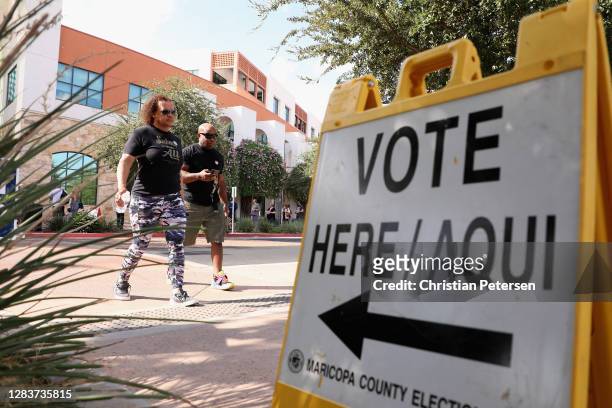 Sadiq and Dana Daniels cross the street after voting at the Surprise Court House polling location on November 03, 2020 in Surprise, Arizona. After a...