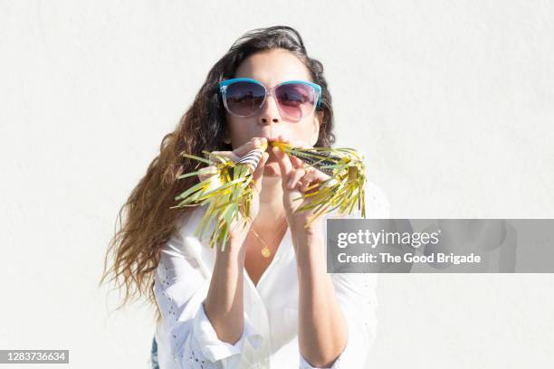 portrait of woman with party favors - matasuegras fotografías e imágenes de stock