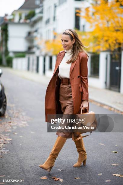 Alexandra Lapp is seen wearing RIANI a-line leather skirt in cognac, PRADA leather coat in cognac, CELINE boots in light brown, Polène bag in brown,...