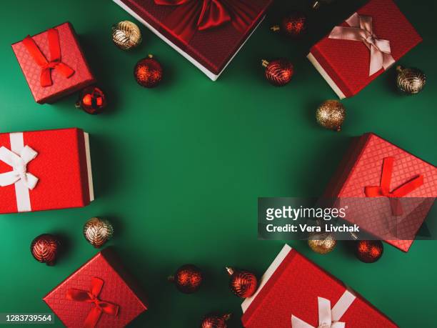 red gift boxes on green background. christmas card. flat lay. top view with space for text. new year composition - build presents suits stockfoto's en -beelden