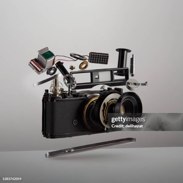 parti e componenti di una fotocamera analogica di film vintage smontata che galleggiano nell'aria su sfondo bianco - disassemblare foto e immagini stock