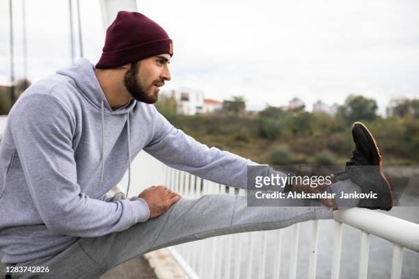a handsome man having a hamstring stretch - hamstring stock pictures, royalty-free photos & images