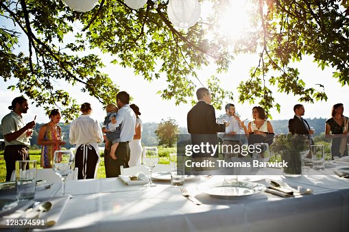 Wedding party standing eating appetizers in field Wedding party standing eating appetizers in field
