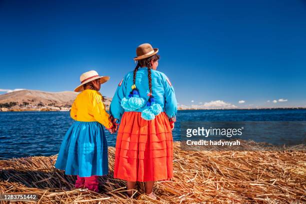 madre e sua figlia guardando vista su uros isola galleggiante, lago tititcaca, perù - perù foto e immagini stock