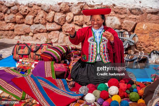 donna peruviana che vende souvenir alle rovine inca, valle sacra, perù - cuzco foto e immagini stock