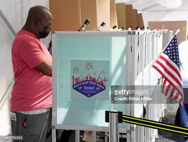 Tyrone Johnson votes inside a tent at a shopping center parking lot on November 3, 2020 in North Las Vegas, Nevada. After a record-breaking early...