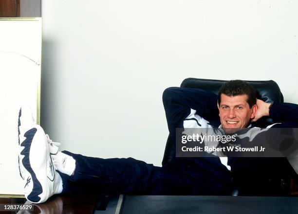 Smiling UConn women's basketball coach Geno Auriemma relaxes behind his desk at Gampel Pavilion, Storrs CT 1995.