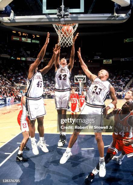 UConn's Eric Hayward, left, Donyell Marshall, center, and Donny Marshall, right, surround a rebound during a Big East game against St. John's...