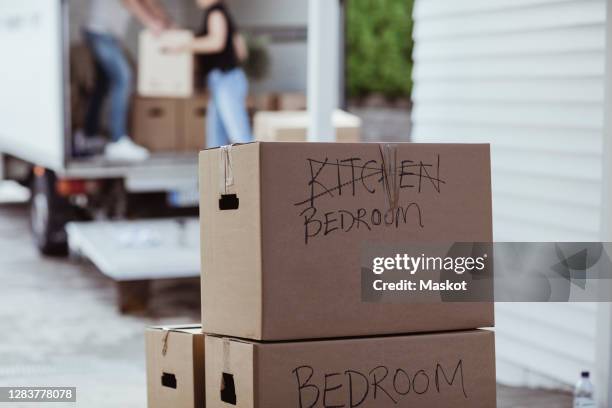 close-up of cardboard box against moving van - lower house stock pictures, royalty-free photos & images