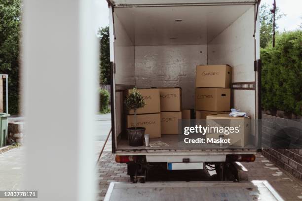 cardboard boxes arranged in back of moving truck - moving truck stock pictures, royalty-free photos & images