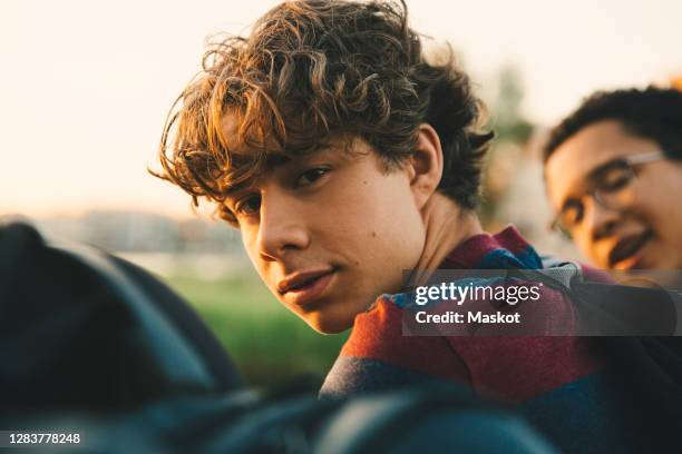 portrait of male teenager with friends standing in city - boys photos et images de collection