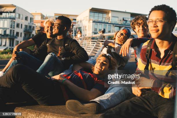 smiling young and teenage friends enjoying at harbor in city - city friends sun bildbanksfoton och bilder