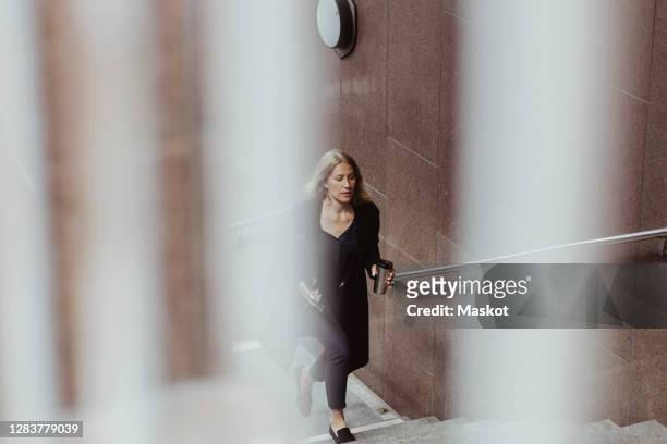 businesswoman with coffee cup climbing staircase in city - woman hurry 個照片及圖片檔
