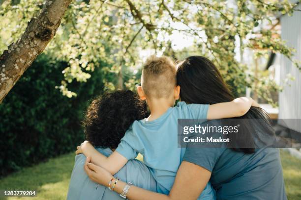 rear view of homosexual mothers with son in backyard - lésbica imagens e fotografias de stock
