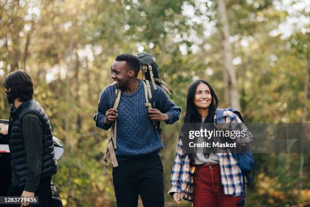 smiling friends looking away during camping - 3 guy friends road trip stock pictures, royalty-free photos & images