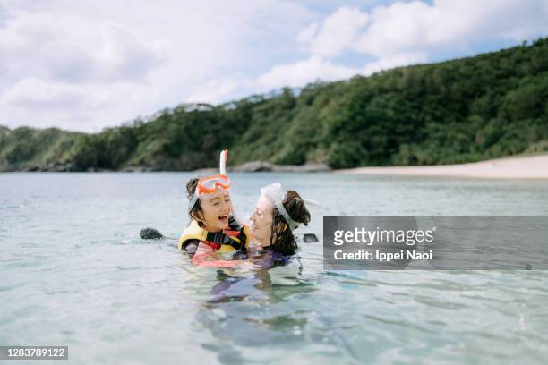 mother and daughter playing in clear water - beach holiday stock pictures, royalty-free photos & images