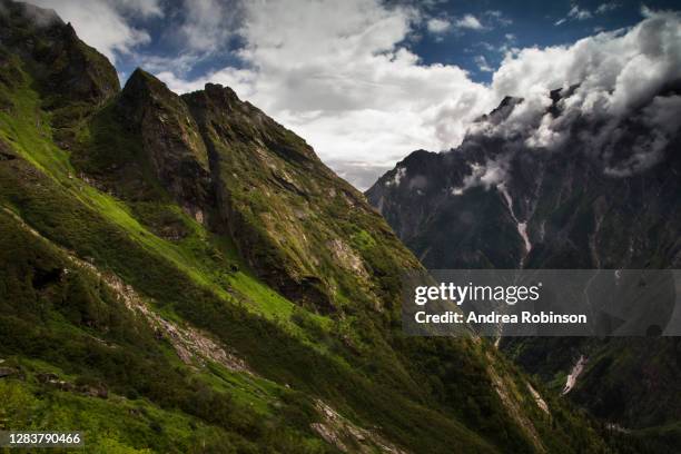 rugged mountains and snow capped peaks through cloud on the road to sri hemkund sahib sacred pilgrimage site in the valley of flowers in the himalayas - valley of flowers uttarakhand stock-fotos und bilder