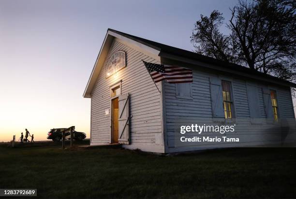 Holly Schuler walks to enter a polling place at dusk to cast her ballot at Sherman Township Hall, a former one room schoolhouse, on November 3, 2020...