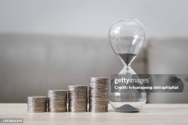 money with an hourglass,saving money - sand clock stock-fotos und bilder