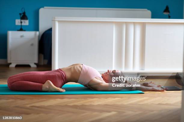 frau im yoga-outfit zu hause in supta virasana - virasana stock-fotos und bilder