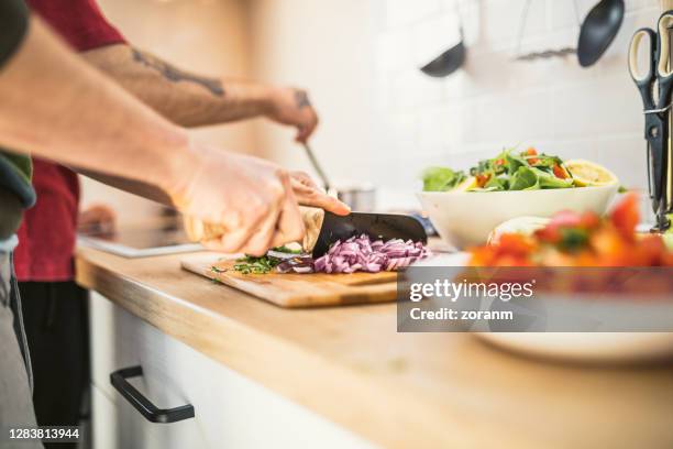 two people chopping spanish onion for salad and cooking - cutting red onion stock pictures, royalty-free photos & images