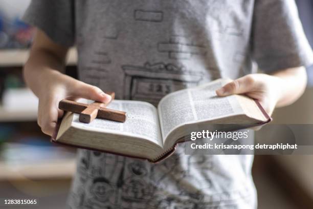 a boy reading the bible - oggetto religioso foto e immagini stock