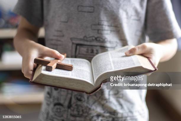 a boy reading the bible - religious equipment stock pictures, royalty-free photos & images