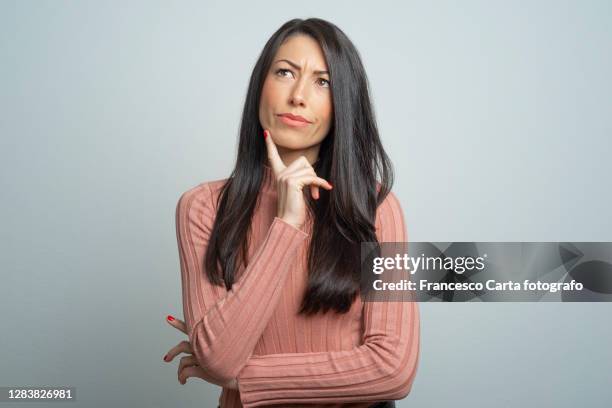 young lady making a thoughtful face - meditar fotografías e imágenes de stock