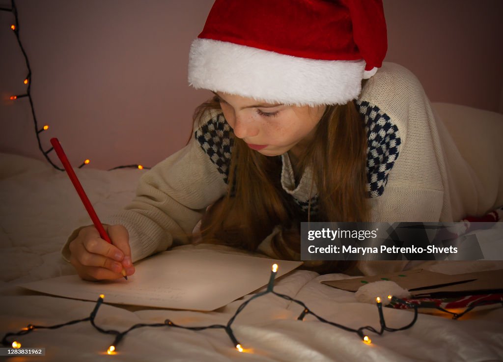 Girl writes a letter to Santa Claus.