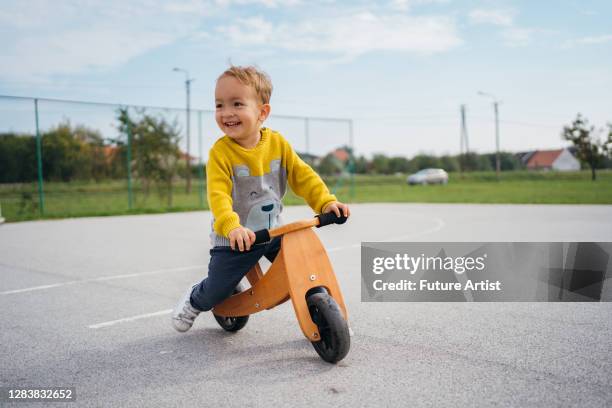 playful toddler boy - baby on bike stock pictures, royalty-free photos & images
