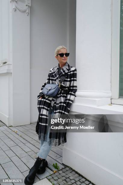 Caro Daur wearing Dior bobby bag and coat, blue jeans and black boots on October 26, 2020 in Hamburg, Germany.