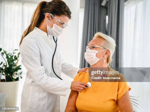 arts die stethoscoop gebruikt die aan hogere patiënten luistert die ademen - auscultation woman stockfoto's en -beelden