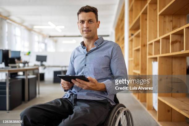 portrait of an entrepreneur sitting on wheelchair - diversidad funcional fotografías e imágenes de stock
