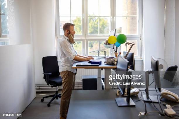 businessman with face mask working at ergonomic desk in office - ergonomic keyboard stock pictures, royalty-free photos & images