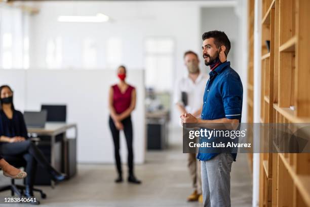 businessman addressing office staff in a meeting - new business covid stock pictures, royalty-free photos & images