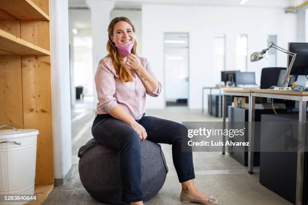 portrait of a happy businesswoman sitting on a ball chair - ball chair foto e immagini stock