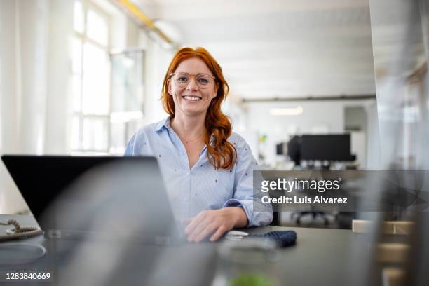 portrait of a successful businesswoman at her desk - frau stock-fotos und bilder