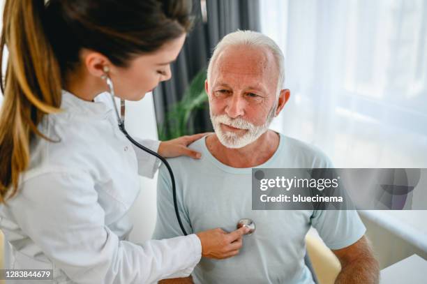 female doctor using stethoscope listening to senior patients breathing - cardiopulmonary system stock pictures, royalty-free photos & images