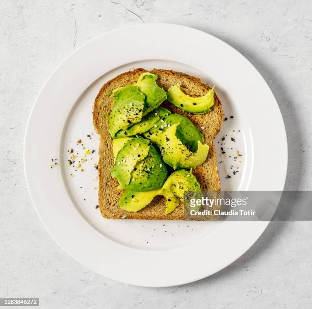 toast with avocado on white background - sanduíche aberta imagens e fotografias de stock
