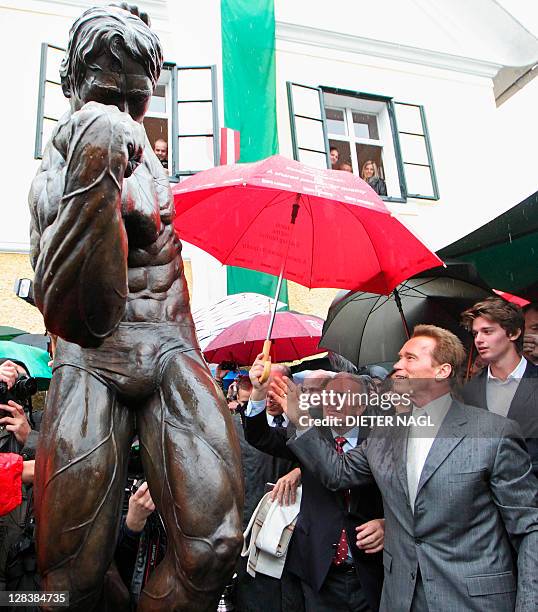 Former California Governor Arnold Schwarzenegger and his son Patrick attend on October 7, 2011 the unveiling of a statue during the opening of Arnold...