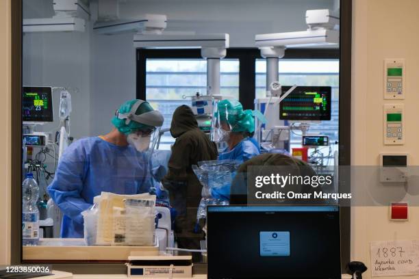 Medical personnel wear protective suits, masks, gloves and face shields during their shift at the ICU of Krakow University Hospital on November 03,...