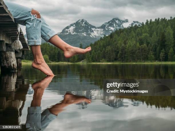 pés pendurados no píer do lago - barefoot women - fotografias e filmes do acervo