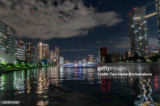 illuminated buildings by the river in tokyo of japan - tsukishima tokyo photos et images de collection