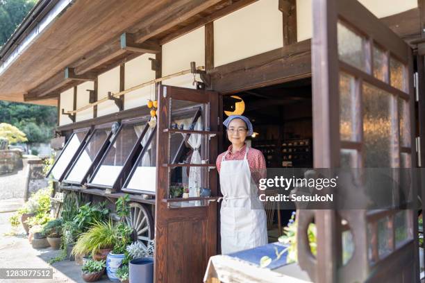 asian fireplace cafe owner smiling - vintage restaurant stock pictures, royalty-free photos & images