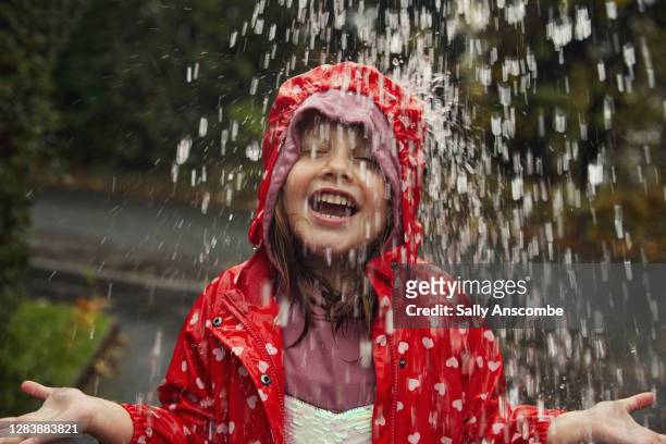 child standing under water drops - standing in the rain girl stockfoto's en -beelden