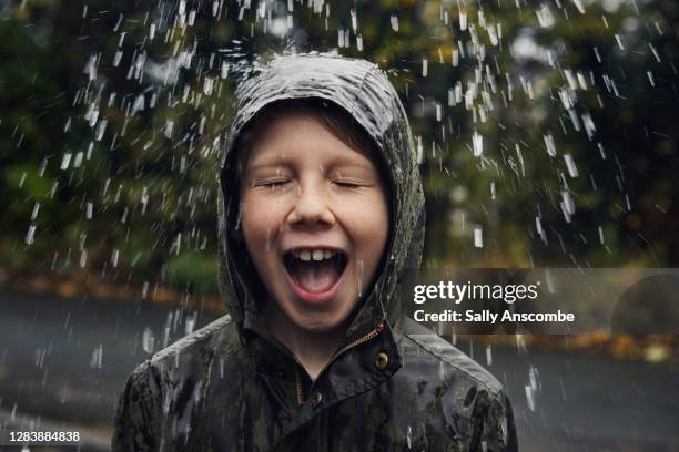 child standing under water drops outside - raincoat ストックフォトと画像