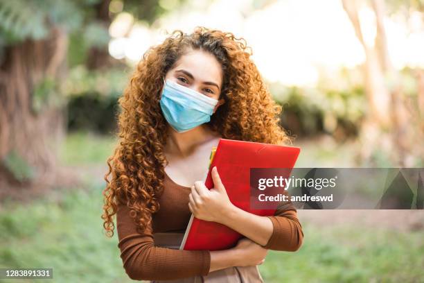 joven estudiante en el campus universitario al aire libre. usar mascarilla de protección facial - el milenio fotografías e imágenes de stock